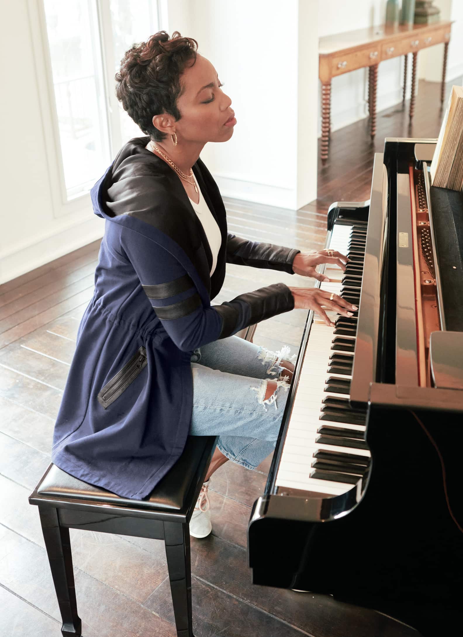 Woman at piano wearing jacket and jeans